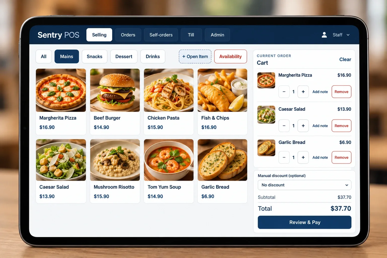 The Sentry Lite selling screen on a tablet: menu items with photos and prices grouped by category, and the current order on the right with quantities, notes, a discount selector and the order total.